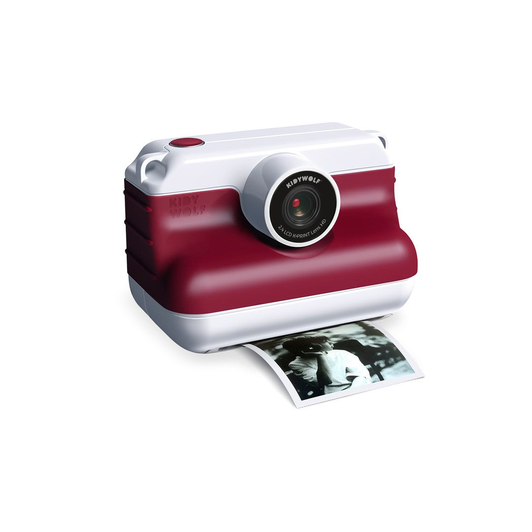Kidywolf K-PRINT instant print camera in red and white, printing a black and white photo from the front
