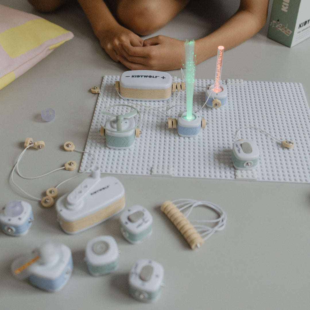 Child playing with kidyelec components blocks on a light surface