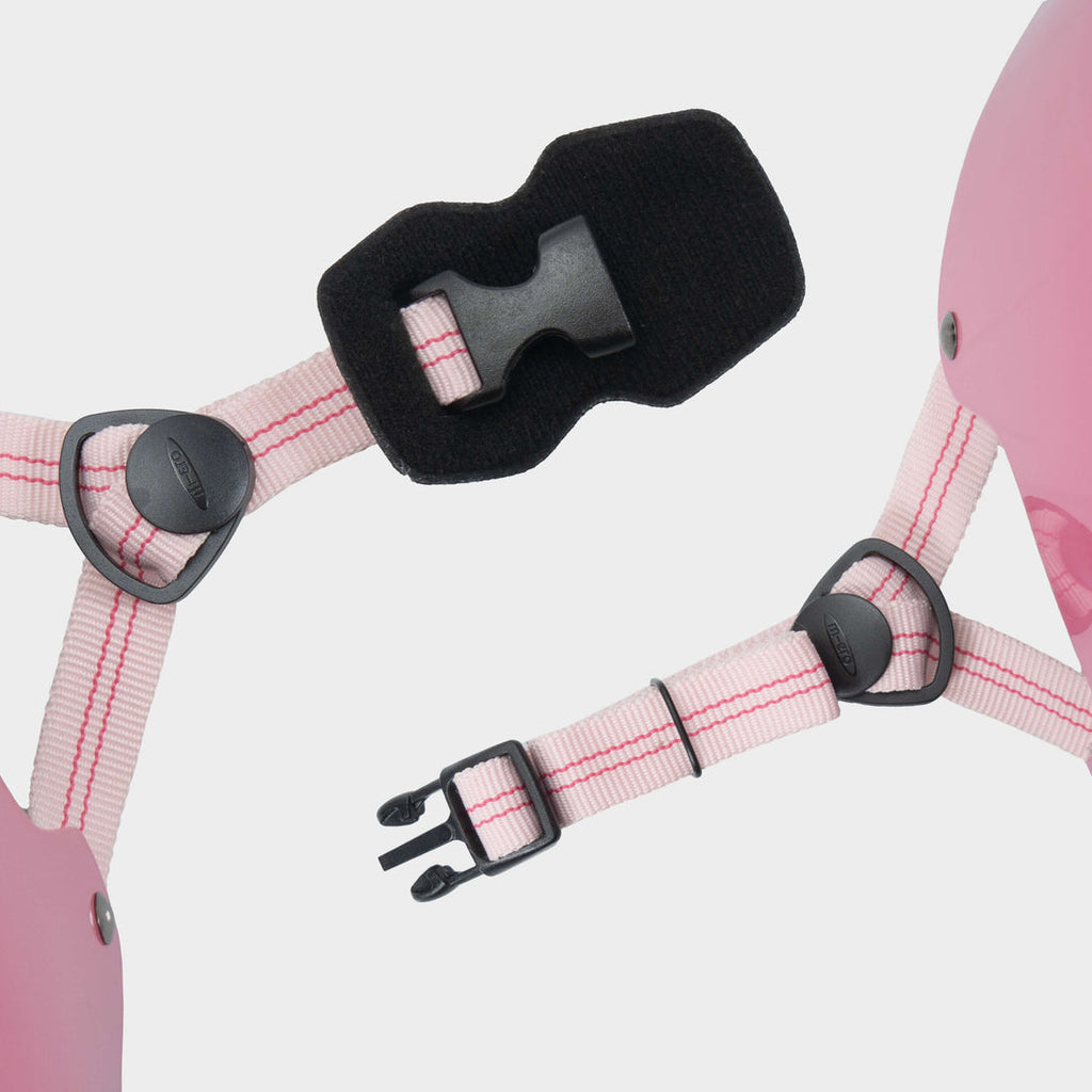 Close-up of the light pink adjustable straps and black buckle on the Micro plain helmet