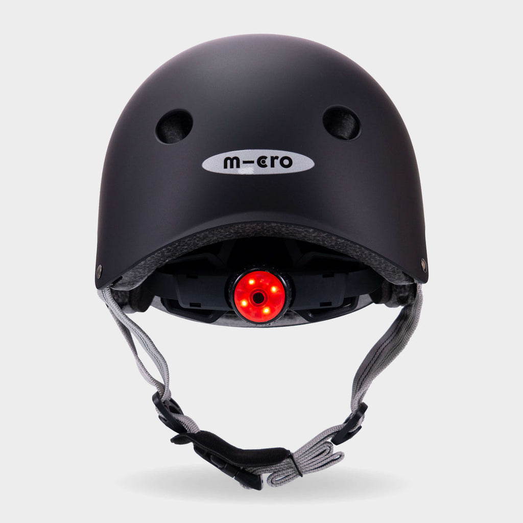 Back of the black Micro plain helmet with the red rear safety light switched on