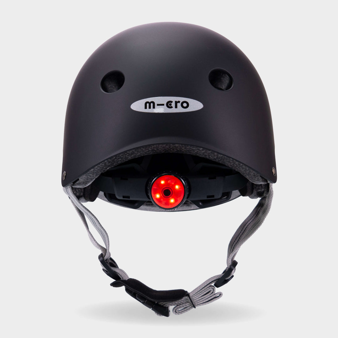 Back of the black Micro plain helmet with the red rear safety light switched on