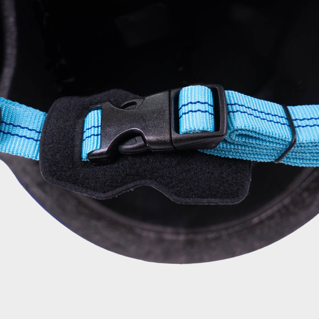 Close-up of the padded chin strap and buckle inside the navy Micro helmet