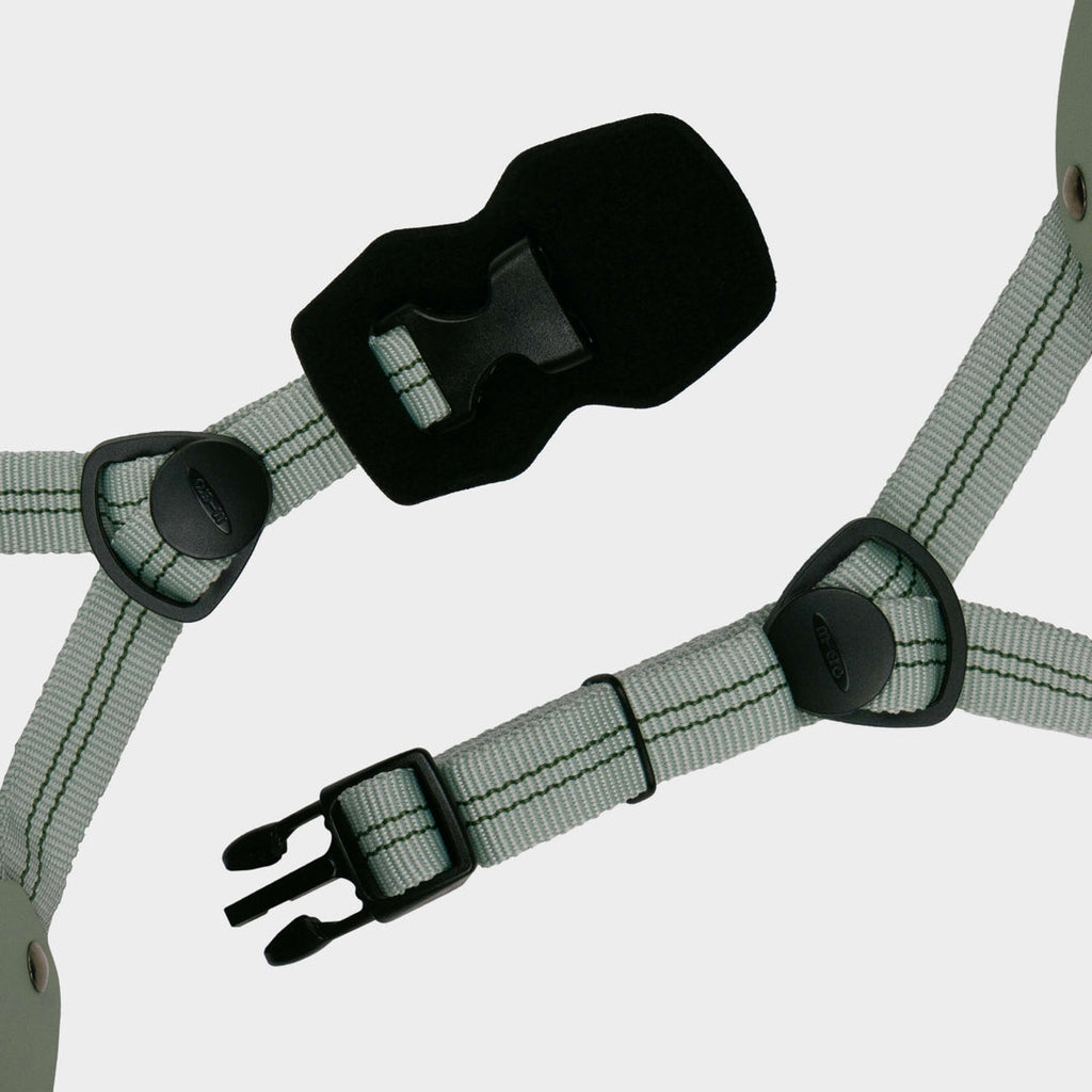 Close-up of the grey-green adjustable straps and black buckle on the Micro plain helmet