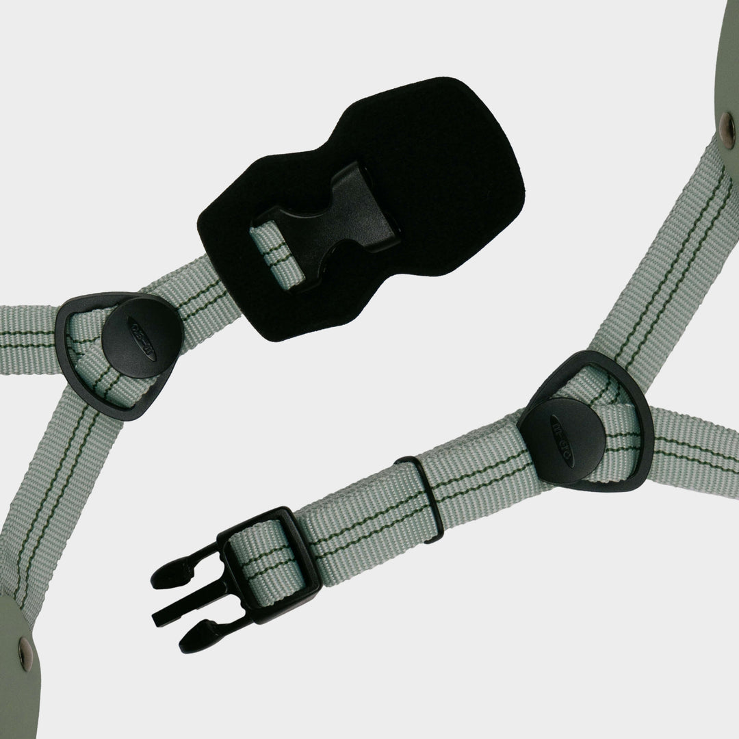 Close-up of the grey-green adjustable straps and black buckle on the Micro plain helmet