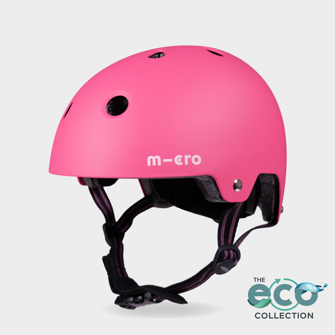 Micro Eco helmet in matt pink with black straps and the Eco Collection logo, front three-quarter view