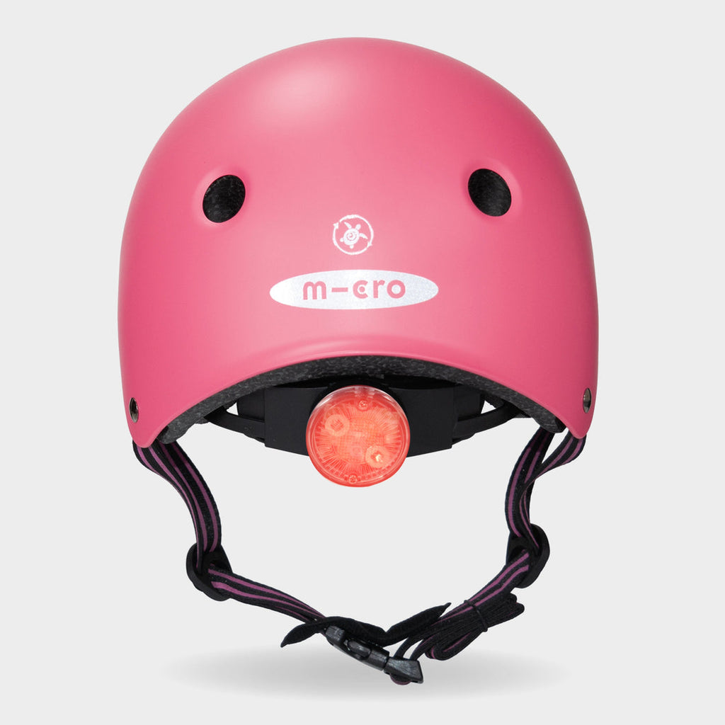 Back of the pink Micro Eco helmet with the red rear safety light switched on