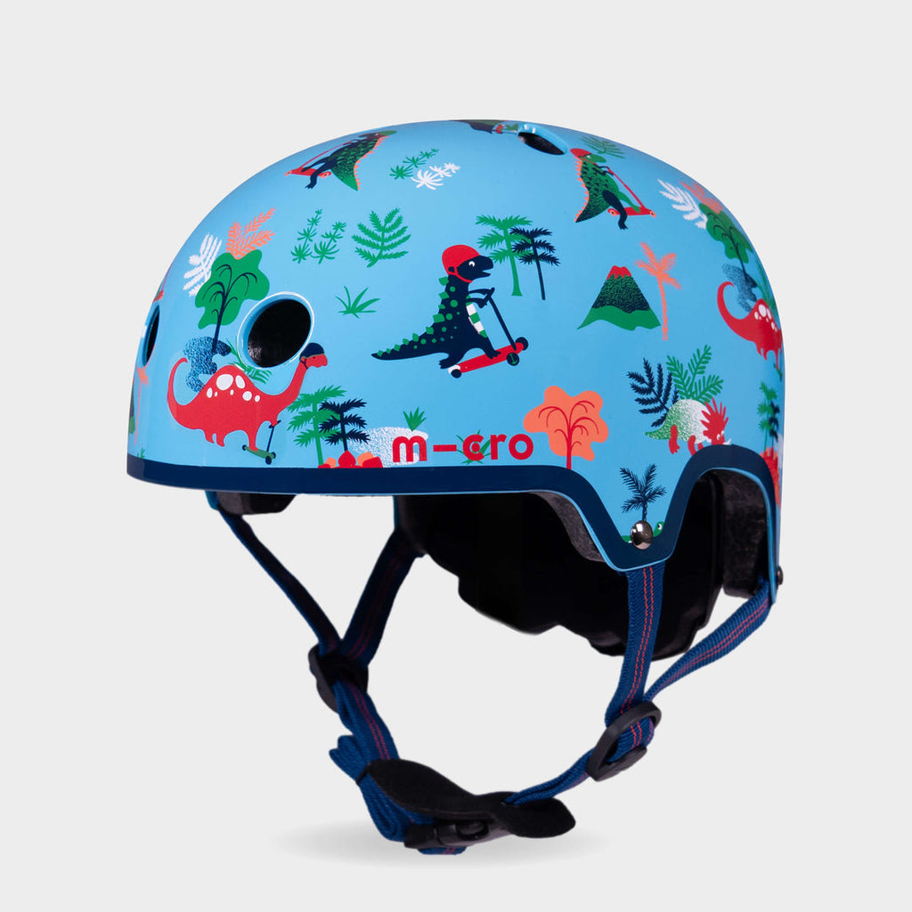 Micro printed helmet in sky blue with a dinosaur, volcano and palm tree pattern, front three-quarter view