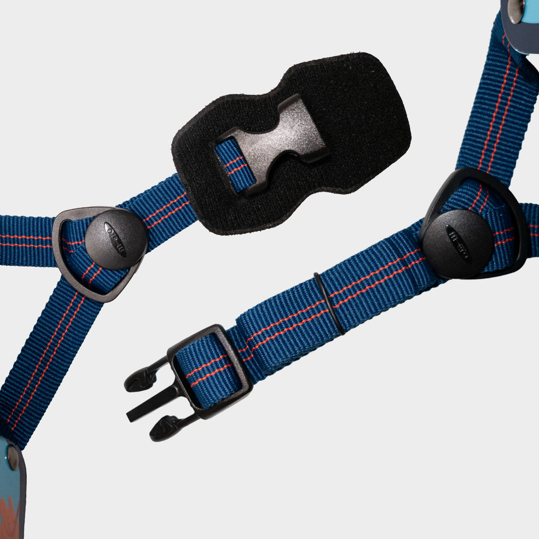 Close-up of the navy adjustable straps and black buckle on the Dino Micro helmet