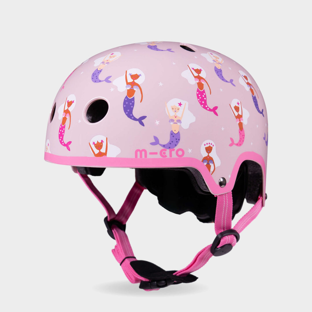 Micro printed helmet in pale pink with a mermaid pattern and bright pink straps, front three-quarter view