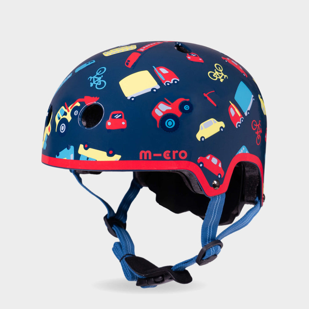 Micro printed helmet in navy with a colourful cars, buses and bikes pattern, red trim and blue straps, front three-quarter view