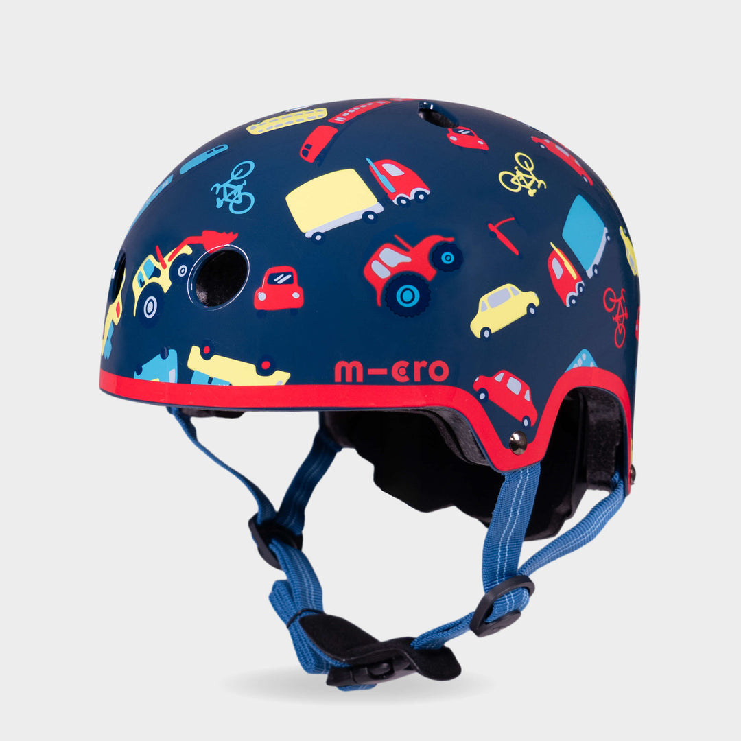 Micro printed helmet in navy with a colourful cars, buses and bikes pattern, red trim and blue straps, front three-quarter view