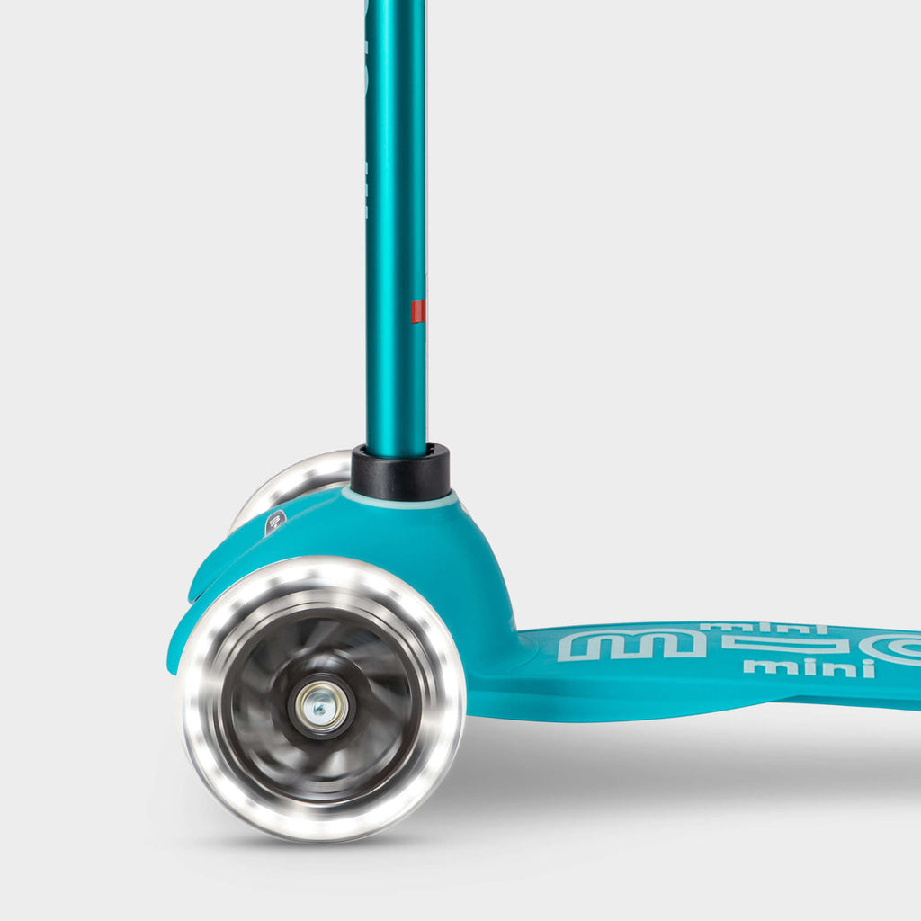 Close-up of the light-up LED front wheels on the aqua Mini Micro Deluxe scooter