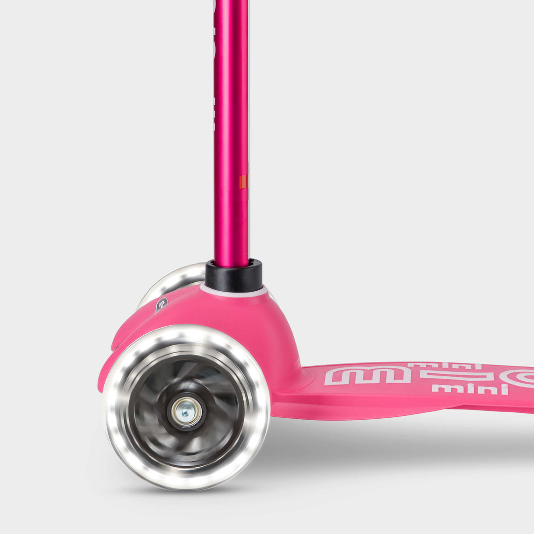 Close-up of the light-up LED front wheels on the pink Mini Micro Deluxe scooter