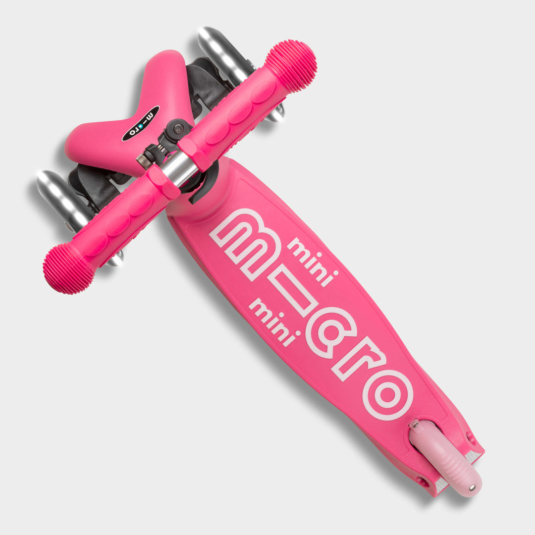 Top-down view of the pink Mini Micro Deluxe deck with the mini micro logo and lean-to-steer front