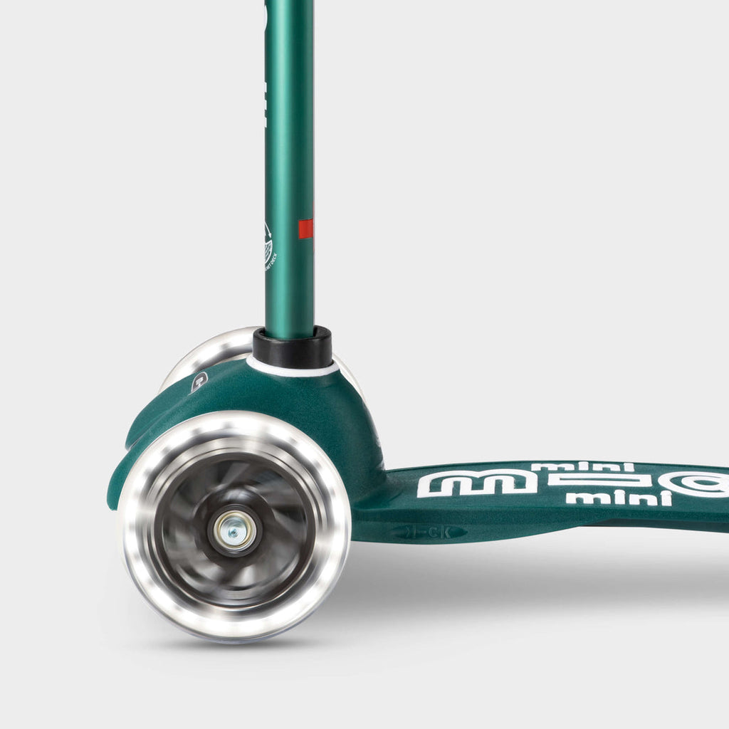 Close-up of the light-up LED front wheels on the green Mini Micro Eco scooter