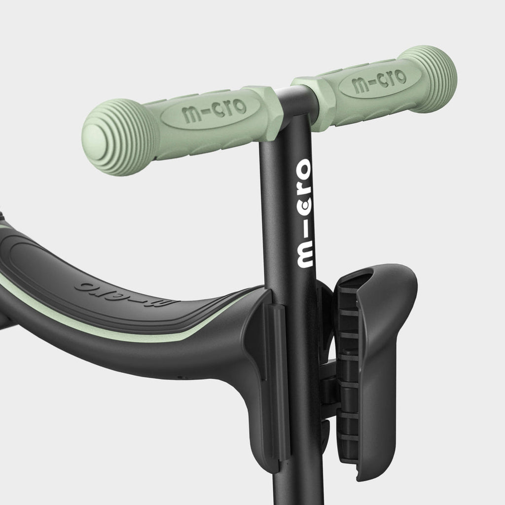 Close-up of the sage green handlebar grips and black seat on the Micro Mini2Grow Deluxe