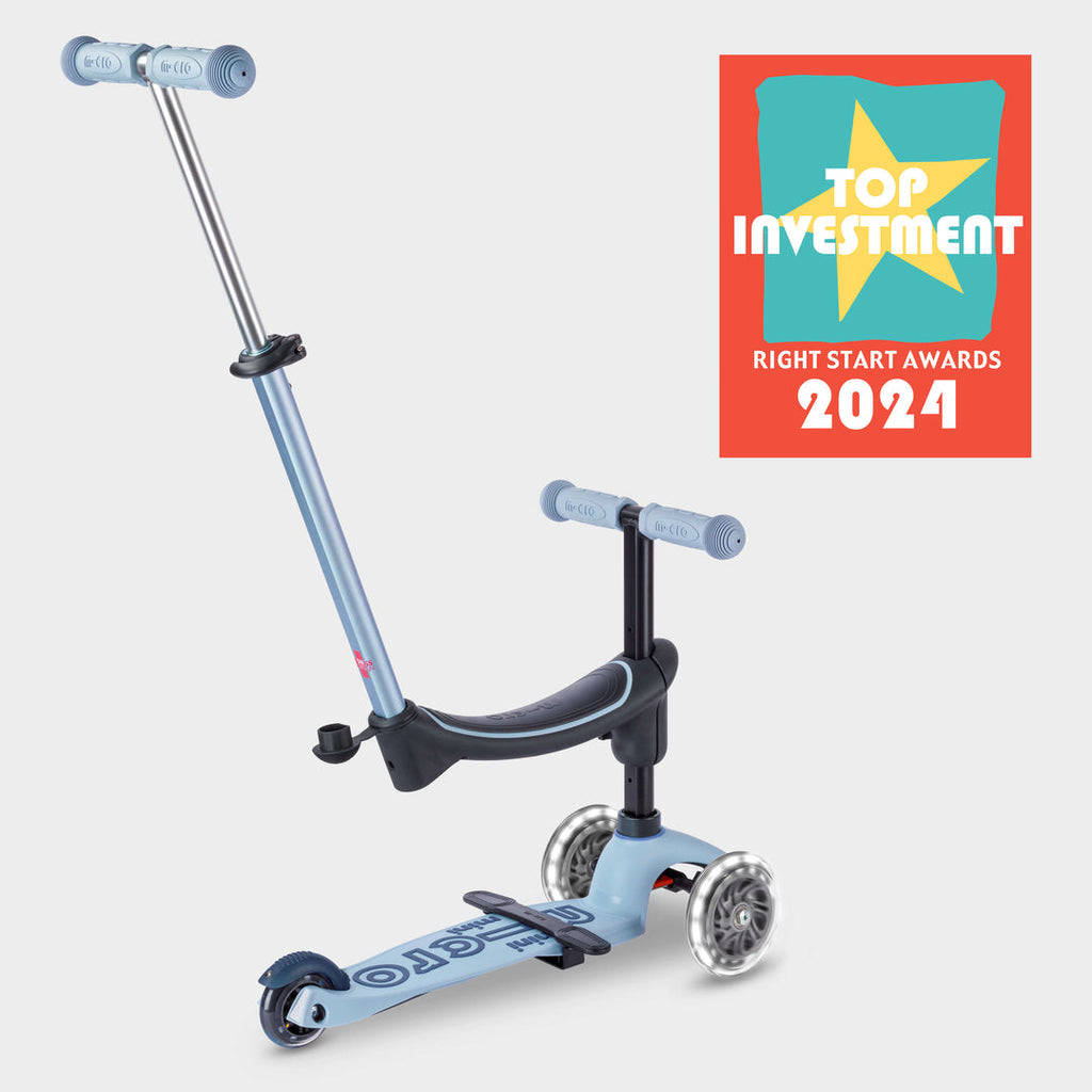 Soft blue Micro Mini2Grow Deluxe ride-on with parent handle and the Right Start Top Investment 2024 award badge