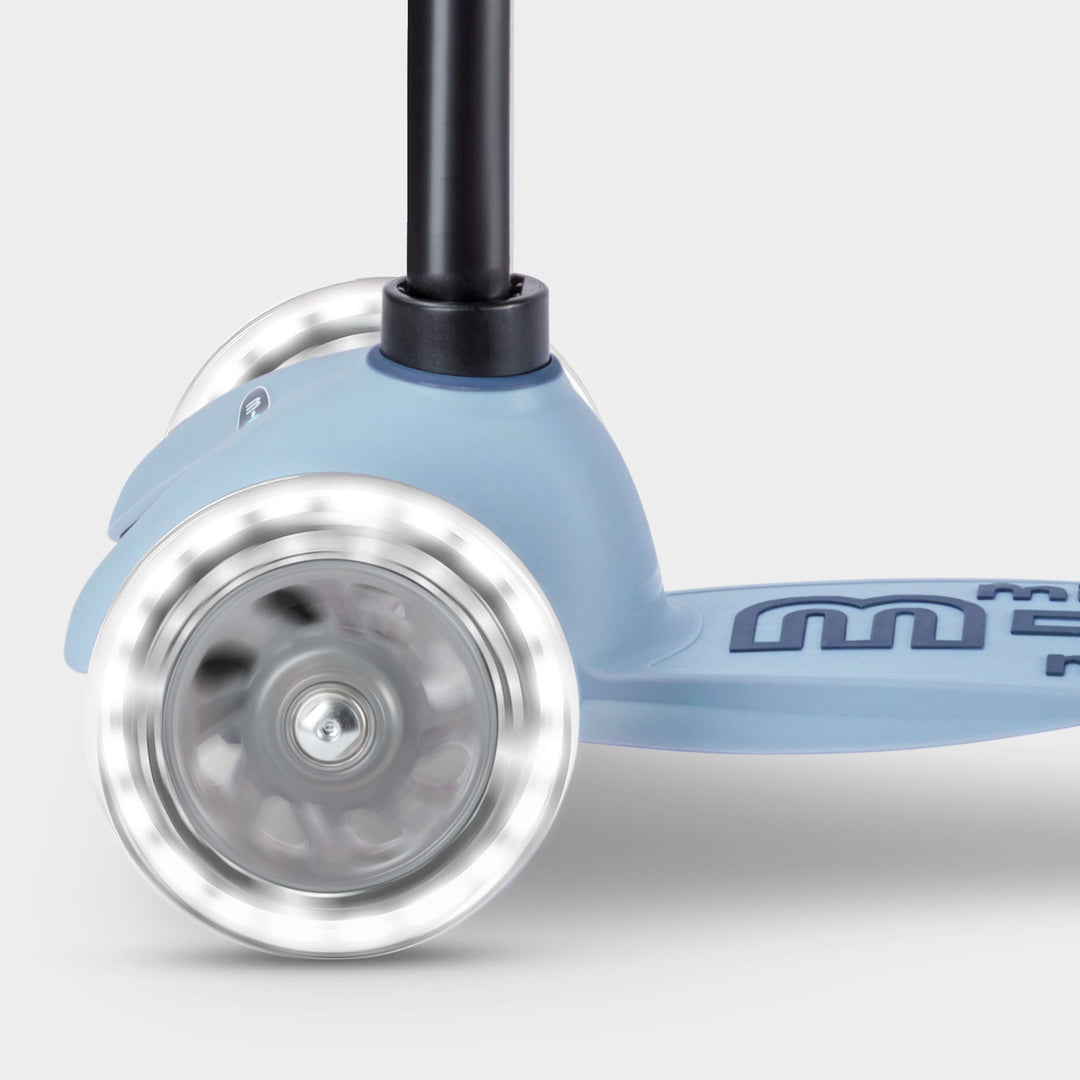 Close-up of the light-up LED front wheels on the soft blue Micro Mini2Grow Deluxe