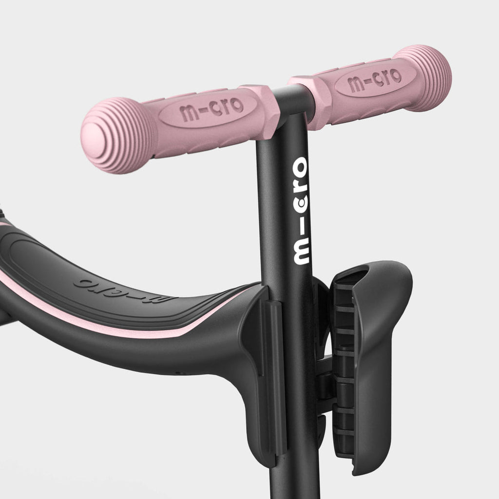 Close-up of the rose pink handlebar grips and black seat on the Micro Mini2Grow Deluxe