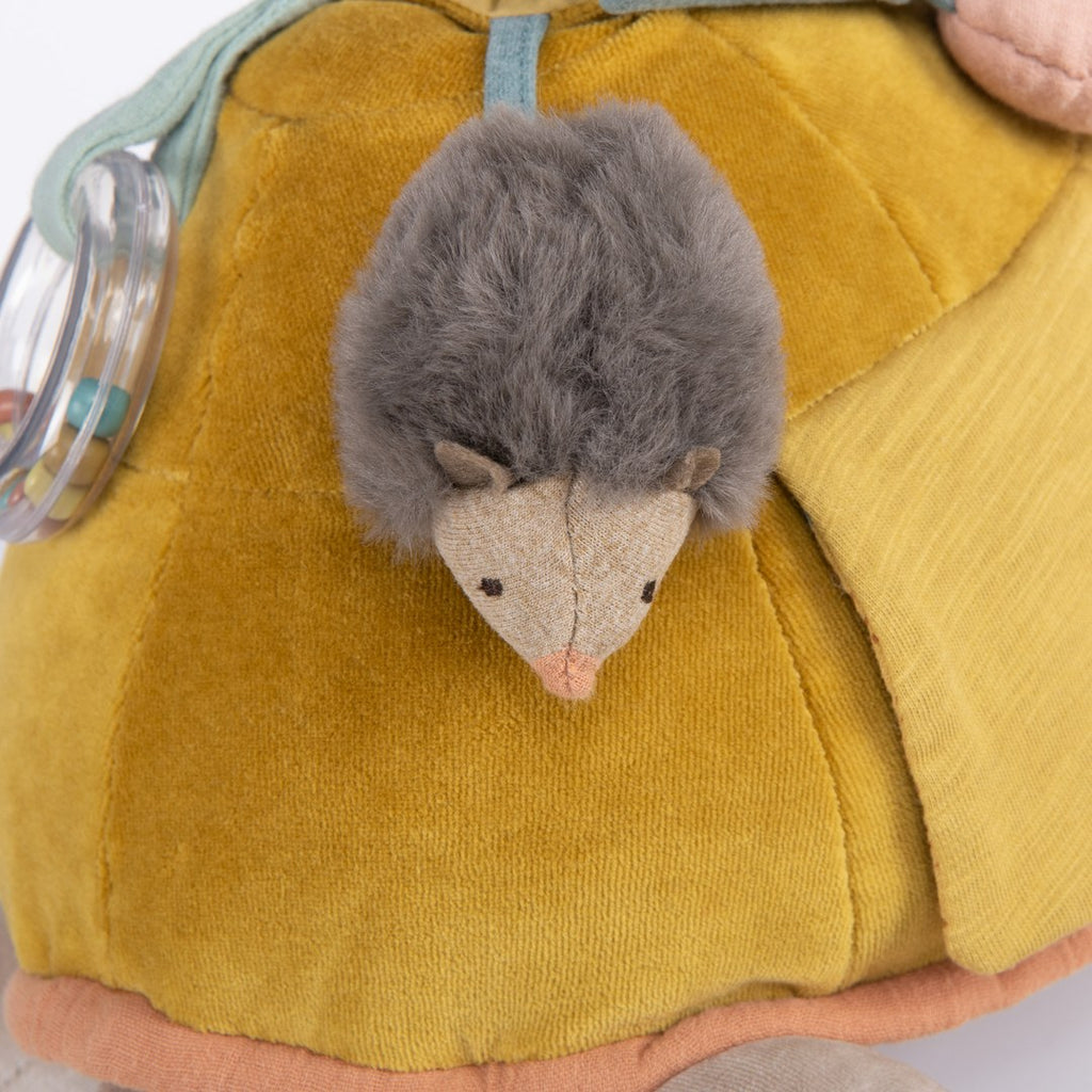 Close-up of the soft hedgehog in the shell pocket of the Moulin Roty activity turtle