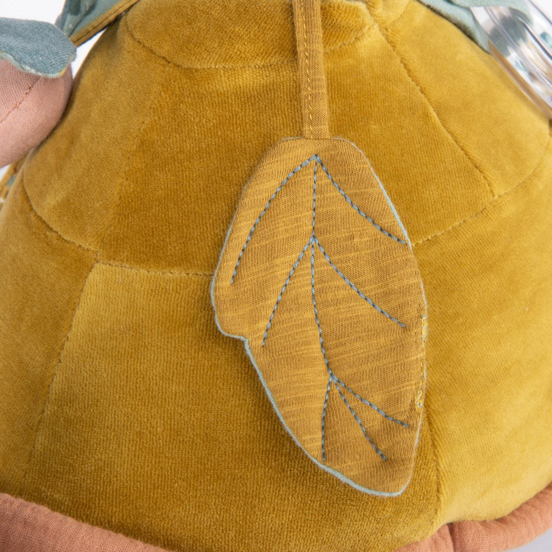 Close-up of the mustard textured fabric leaf on the Moulin Roty activity turtle shell
