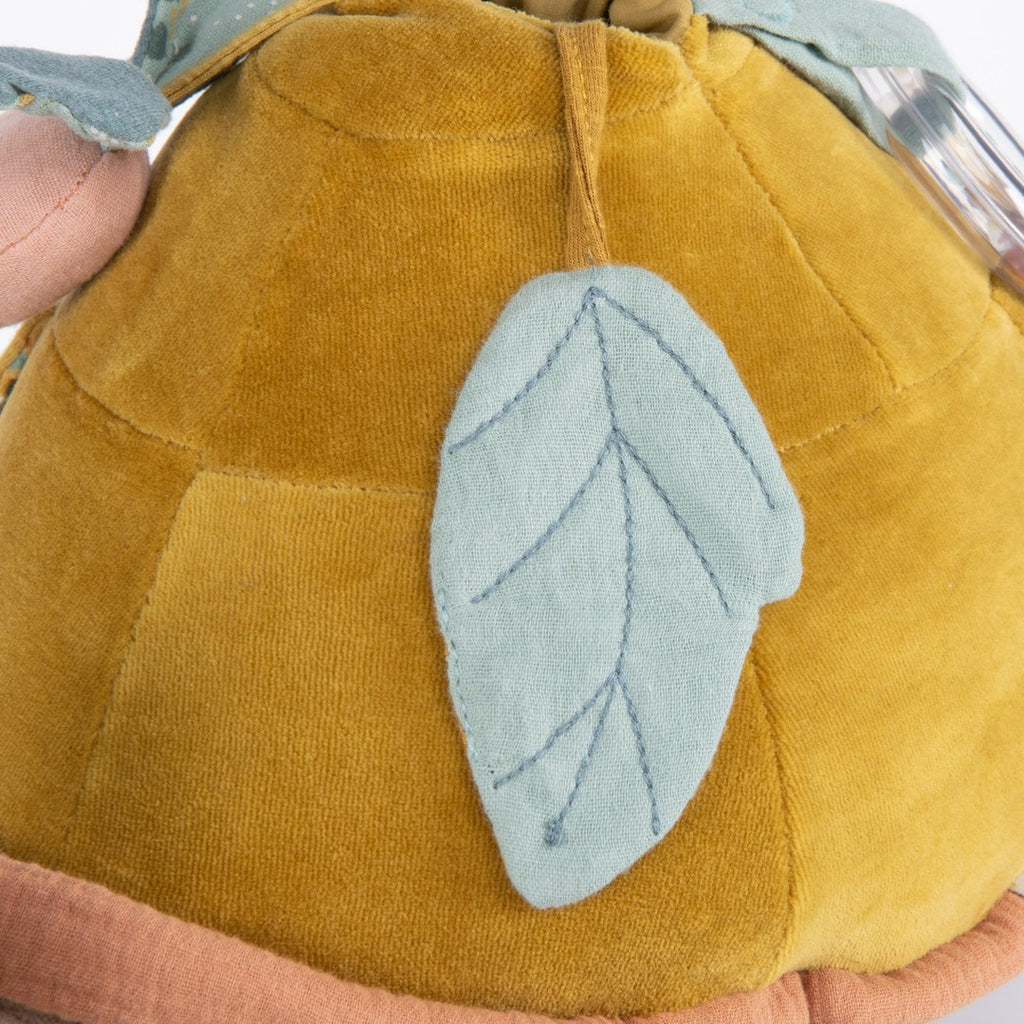 Close-up of the embroidered mint leaf on the Moulin Roty activity turtle shell