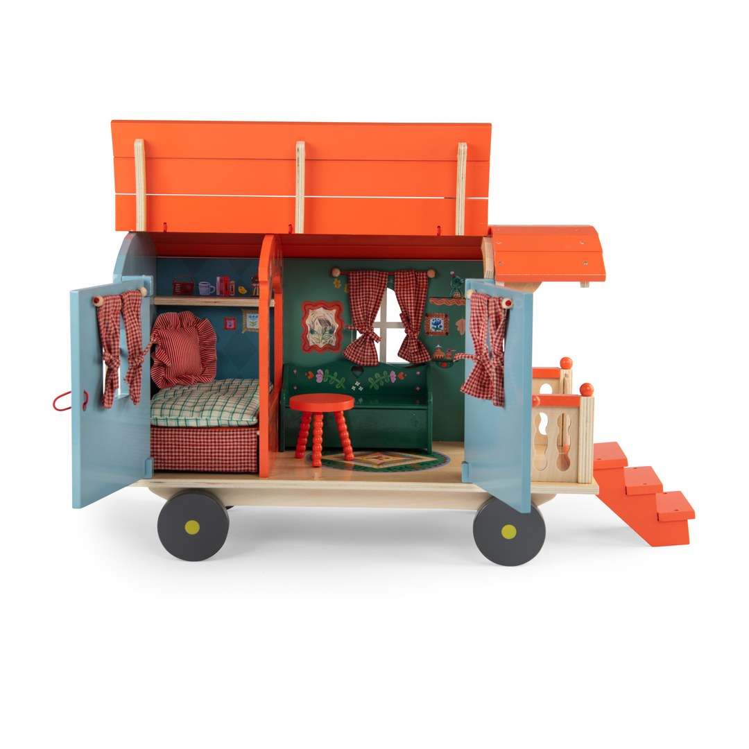 Moulin Roty wooden caravan with side doors and roof open showing the bed, bench and stool inside