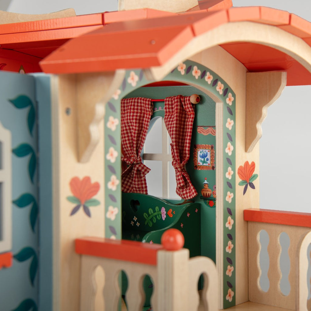 Close-up of the hand-painted arched doorway on the Moulin Roty wooden caravan