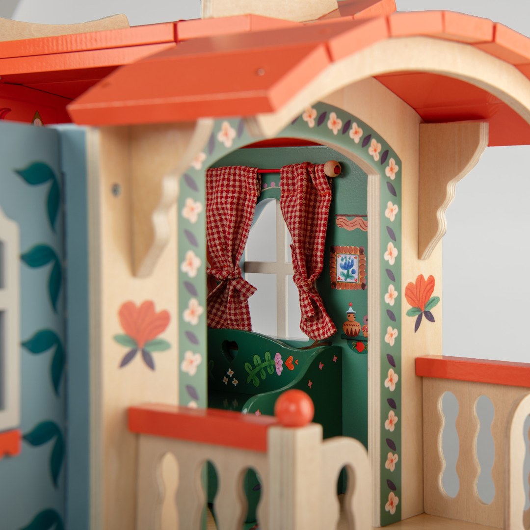 Close-up of the hand-painted arched doorway on the Moulin Roty wooden caravan