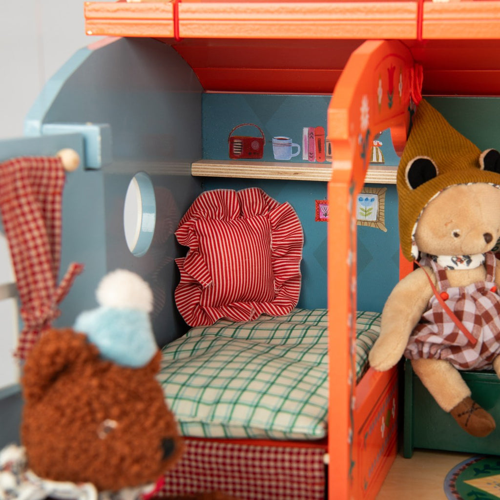 Close-up of the caravan bed with ruffled cushion and checked mattress