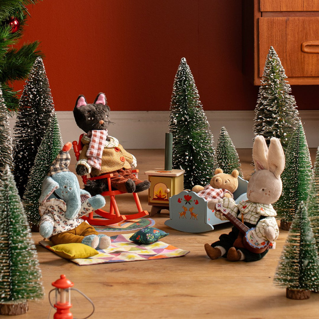 Cat doll in the rocking chair by the stove in a Moulin Roty Christmas scene