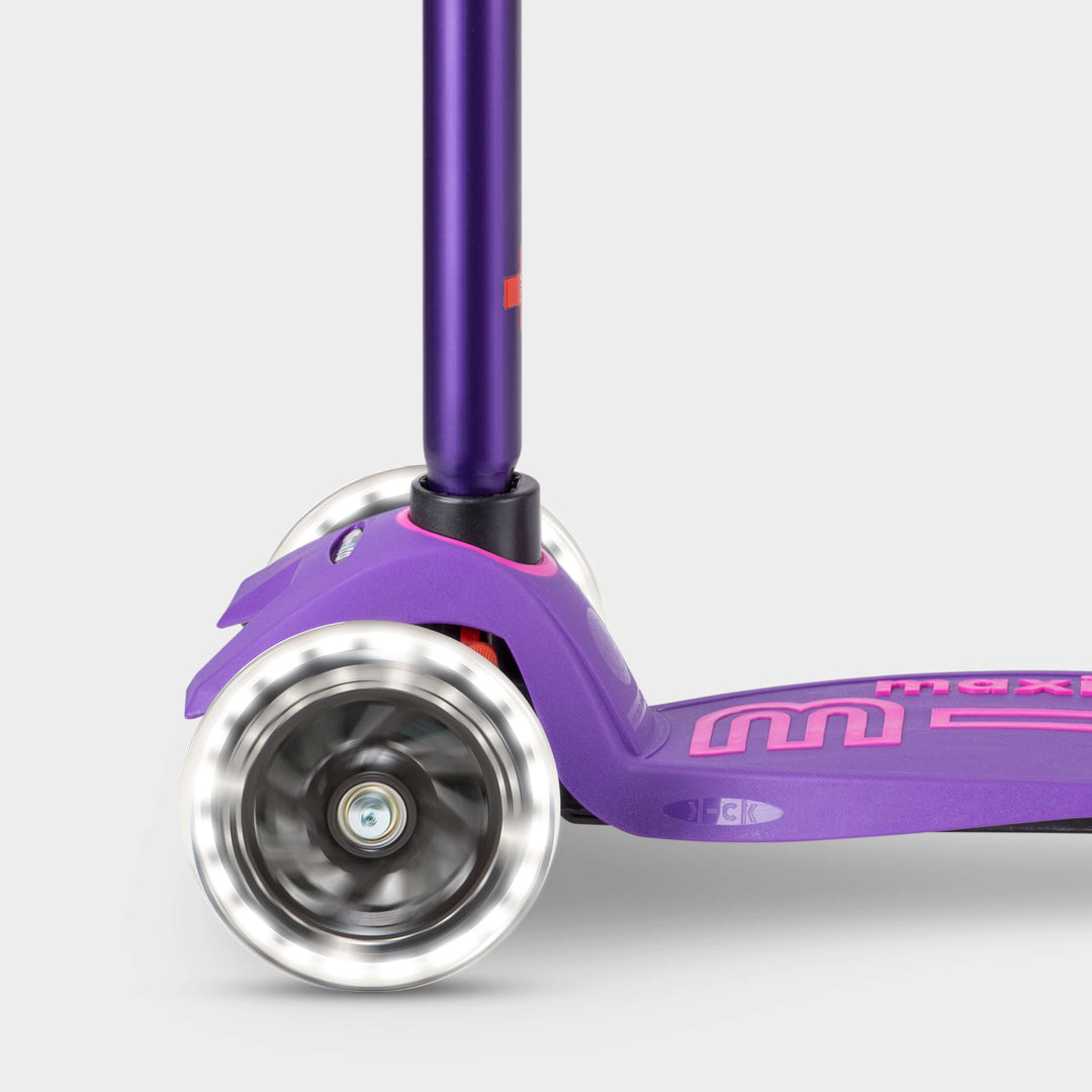 Close-up of the light-up LED front wheels on the purple Maxi Micro Deluxe scooter