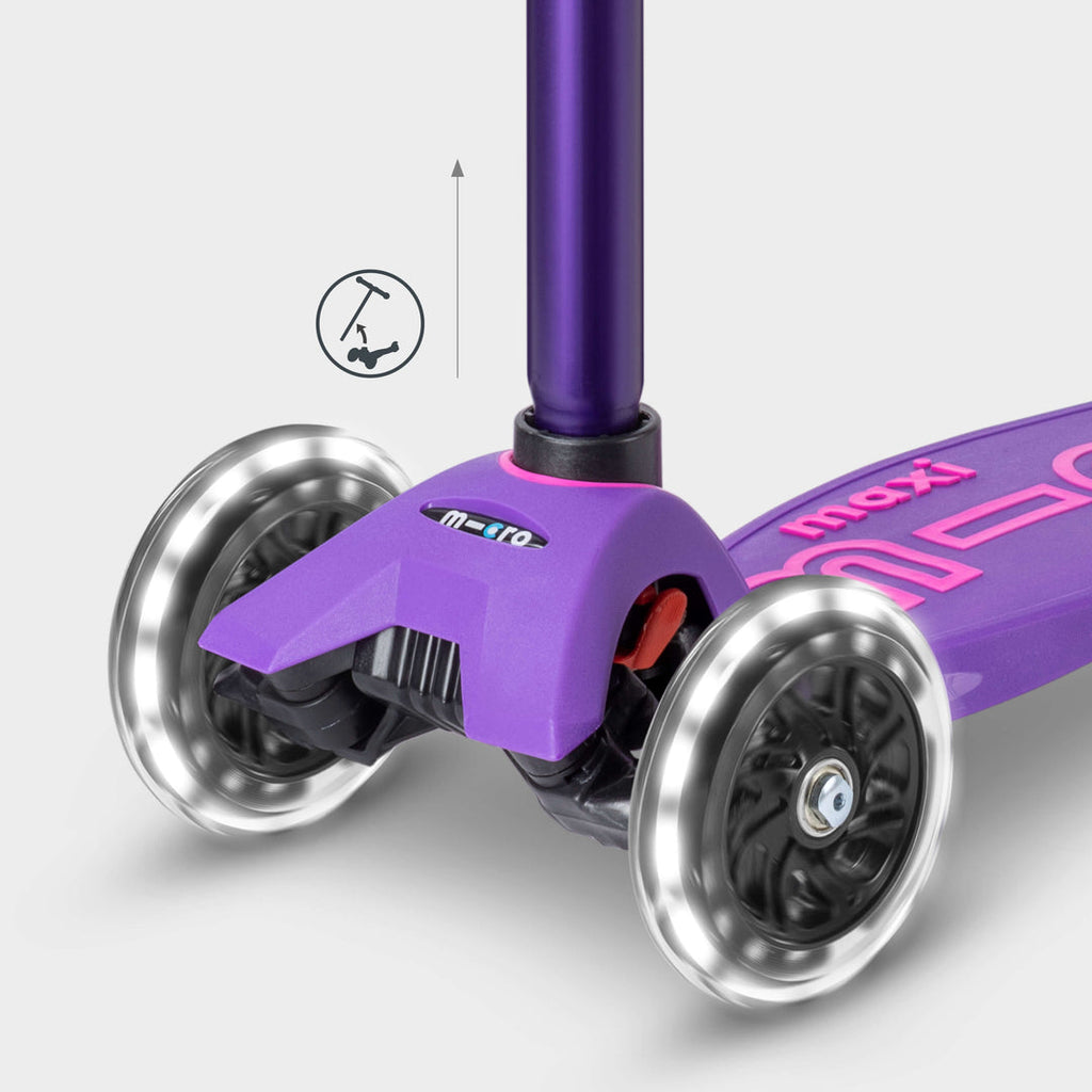 Close-up of the purple Maxi Micro Deluxe front wheels lit up, with a handlebar height-adjust icon