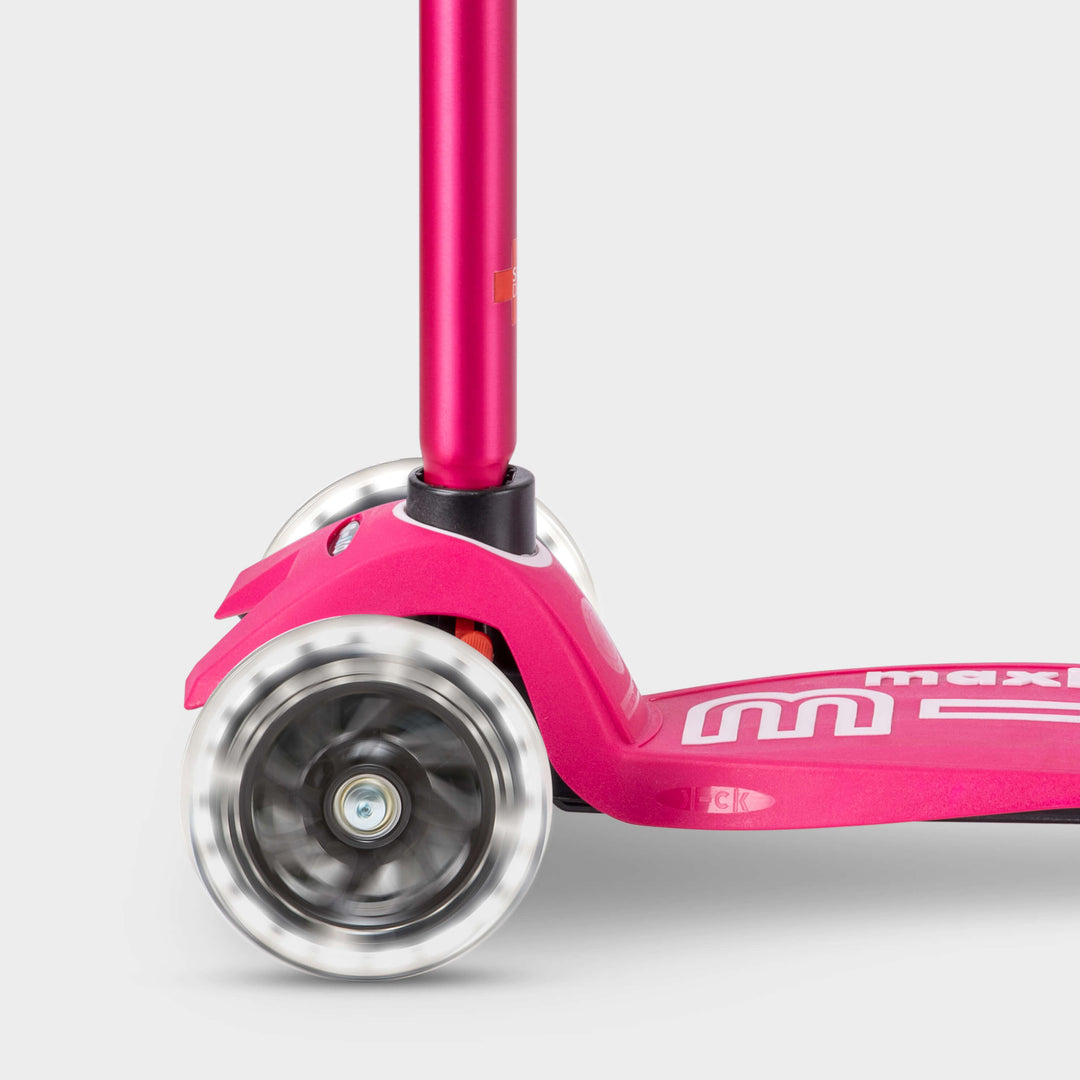Close-up of the light-up LED front wheels on the pink Maxi Micro Deluxe scooter