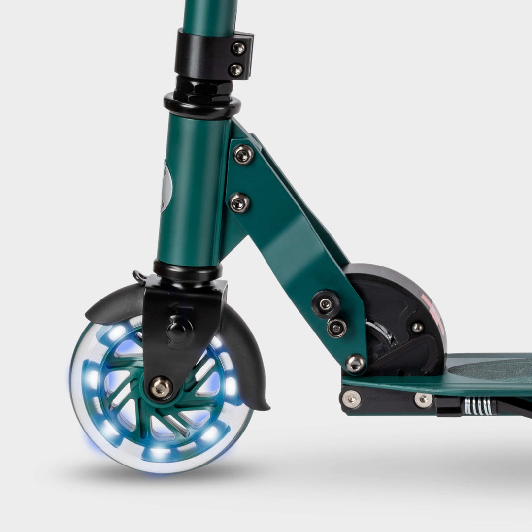 Close-up of the light-up LED front wheel and folding mechanism on the green Micro Recycled Sprite scooter