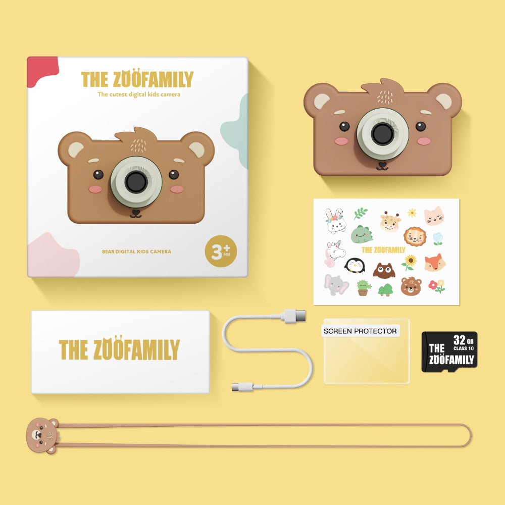 Bear-shaped digital photo camera with accessories on a yellow background, branded 'The Zuö Family'.