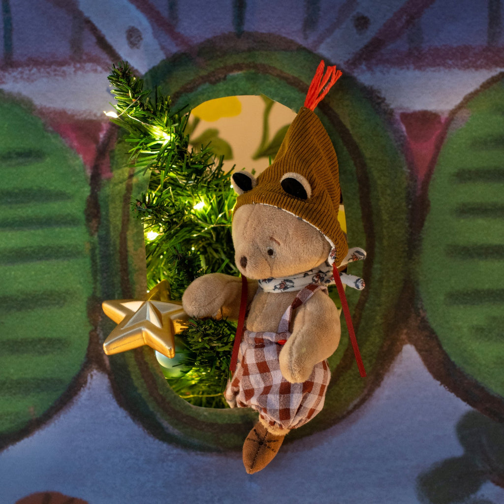 Toy teddy with a star and green tinsel in a decorative frame on a colorful background