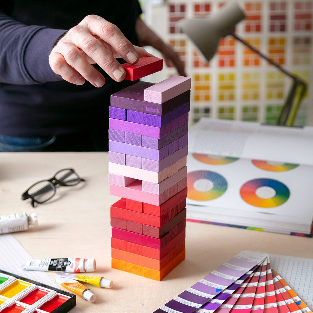 Block Design Warm Gradient Tower, a wooden tumbling tower game with painted blocks in a pink, coral and red gradient, image 5