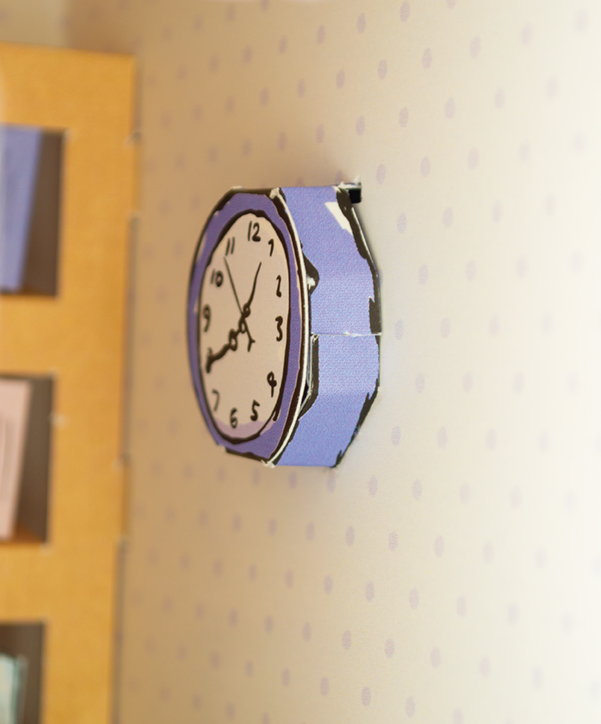 Wall clock with a blue and black design on a white wall.