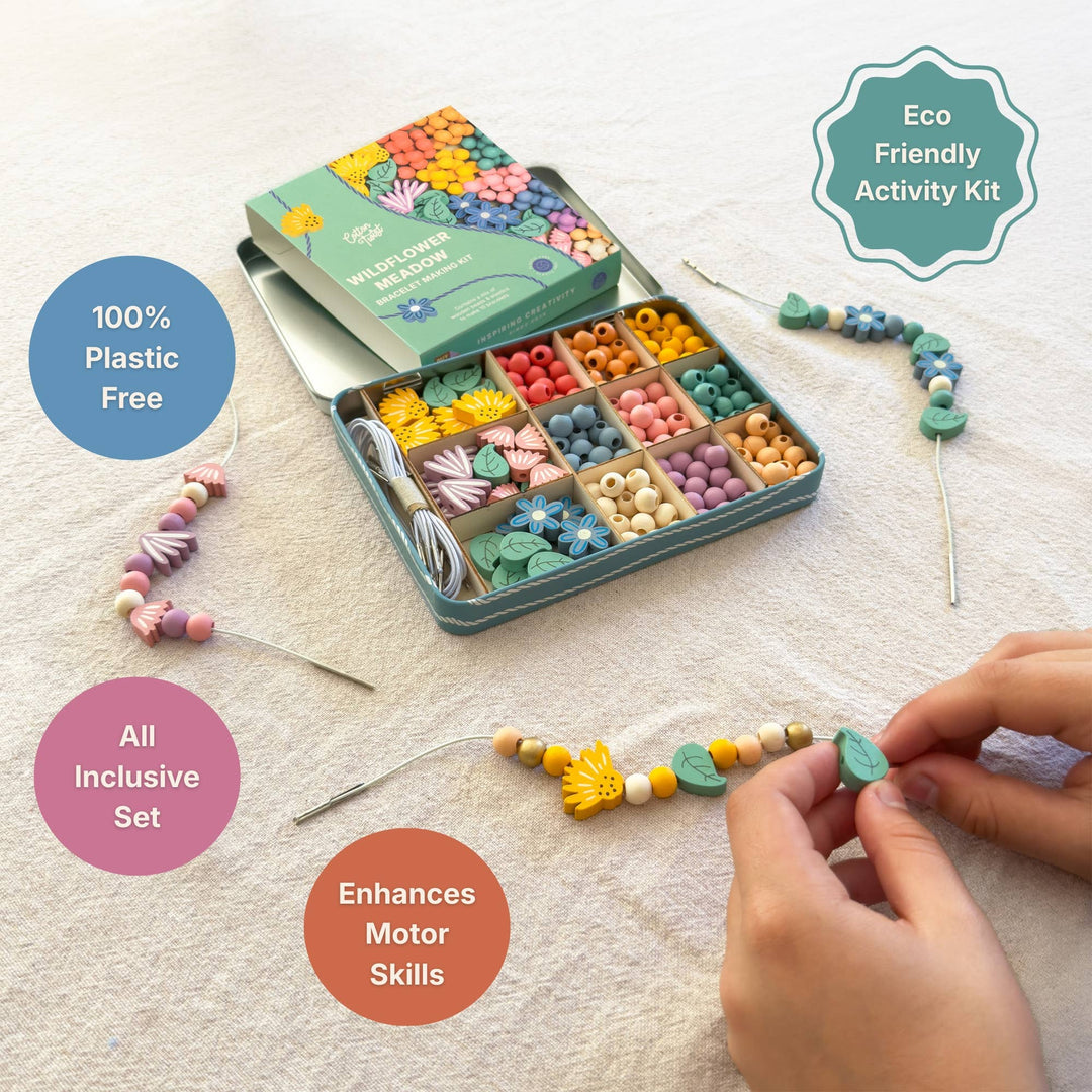 Child threading wooden flower beads beside the open kit tin on a linen background, with badges for 100% plastic free, all-inclusive set, enhances motor skills and eco-friendly activity kit