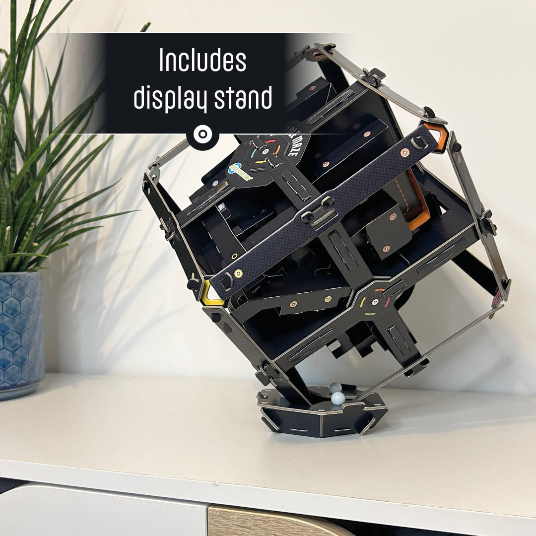 Black geometric display stand on a white surface with text 'Includes display stand'.