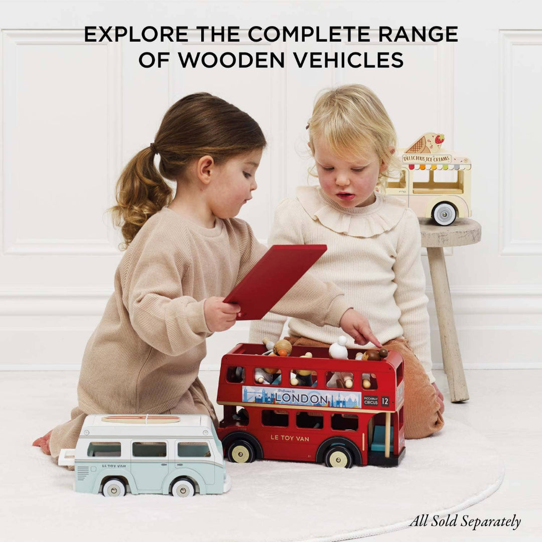 Two children playing with wooden toys on a white floor.