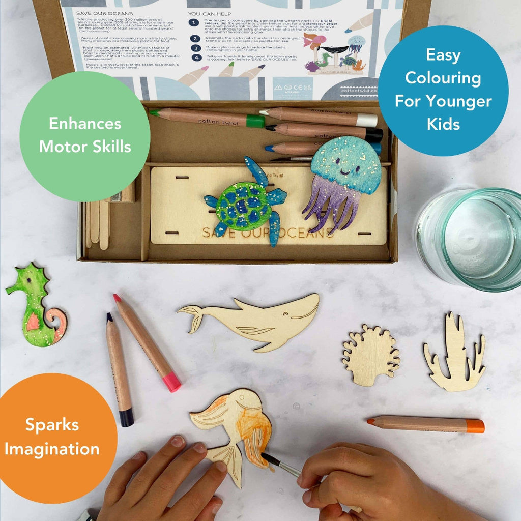Children's art kit with wooden animal shapes, coloring pencils, and water on a marble surface.