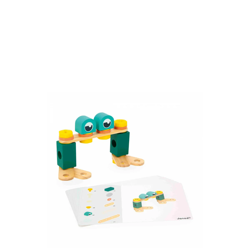 Toy figure of a character with a green body and yellow legs on a white background, featuring Janod branding.