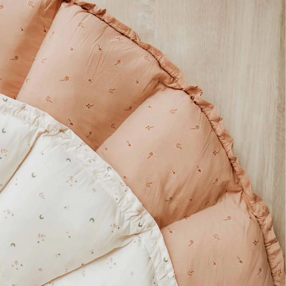 Close-up of a play mat with pink and white patterned fabric to illustrate pattern