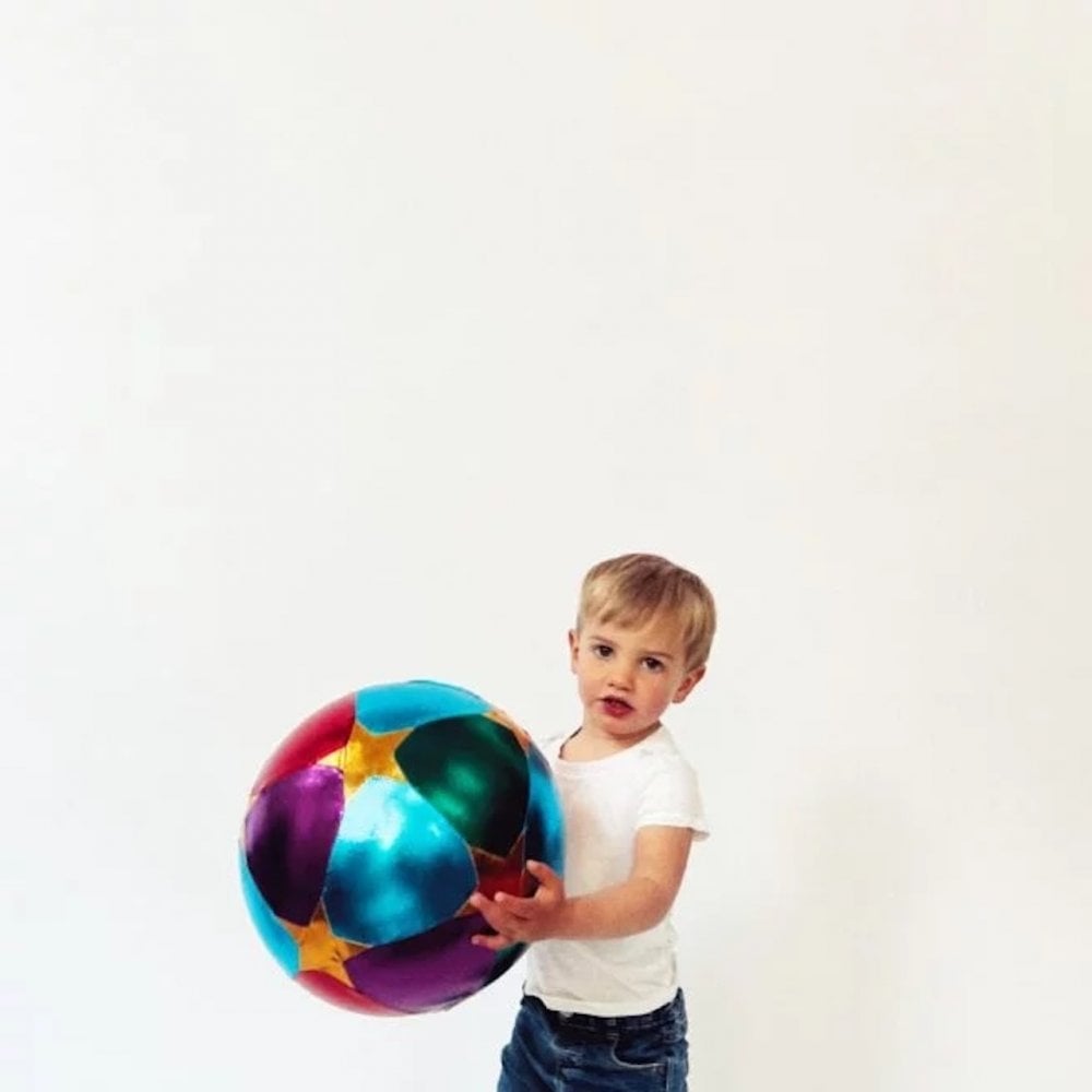 Child holding a colorful ball against a white background