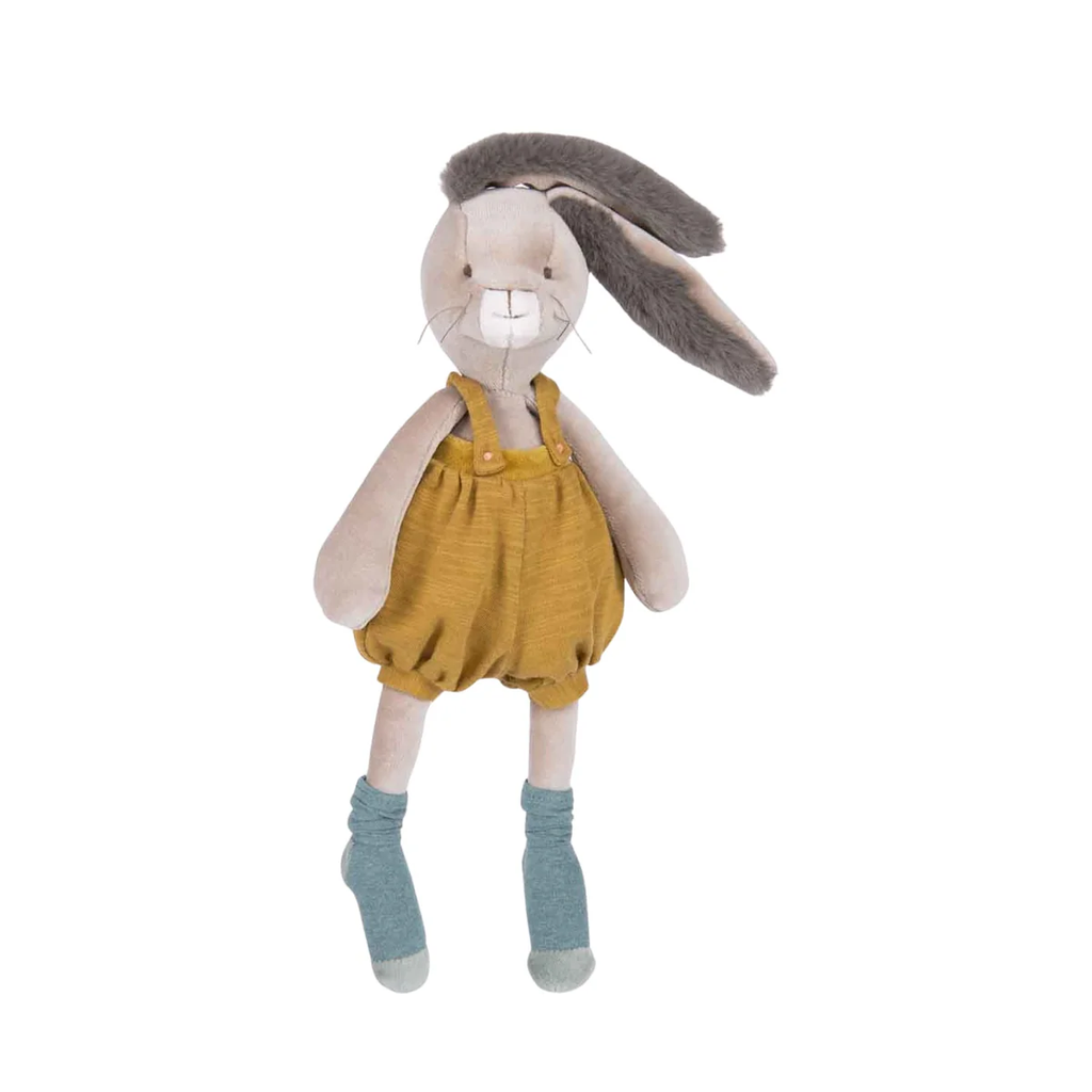 Stuffed toy rabbit wearing mustard yellow overalls on a white background