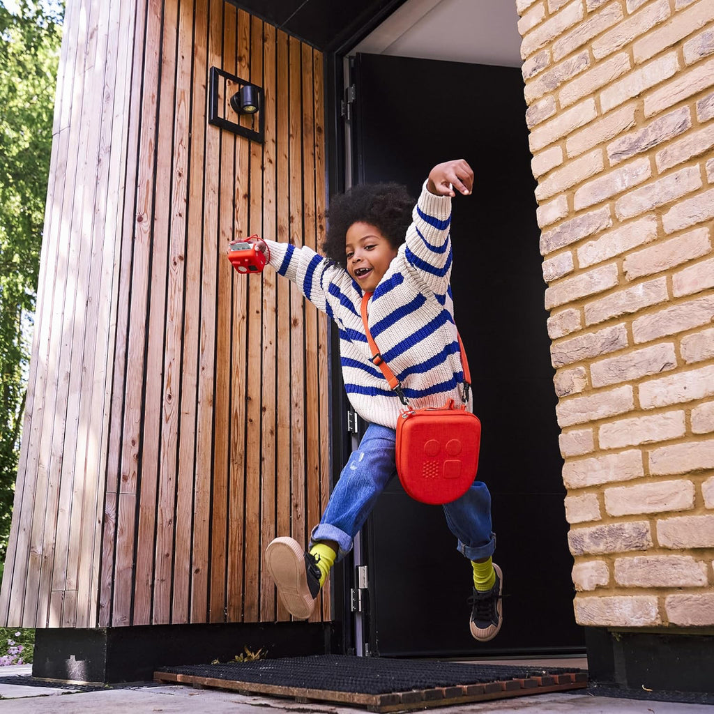 Child jumping out of a small wooden house with a red bag