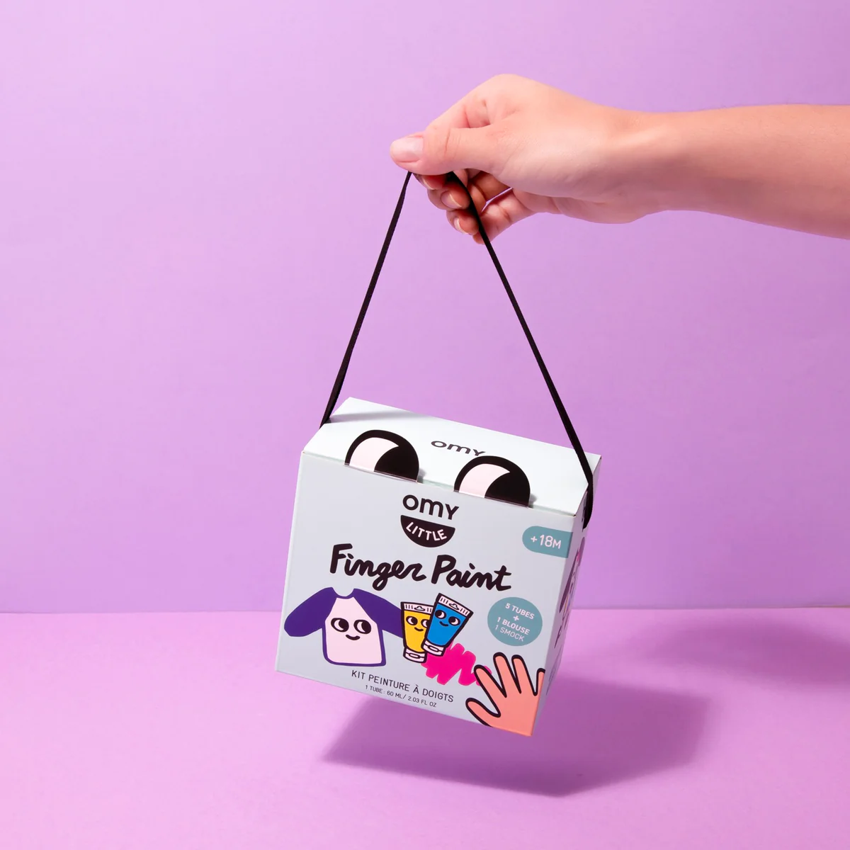 Box for paint kit held on purple background