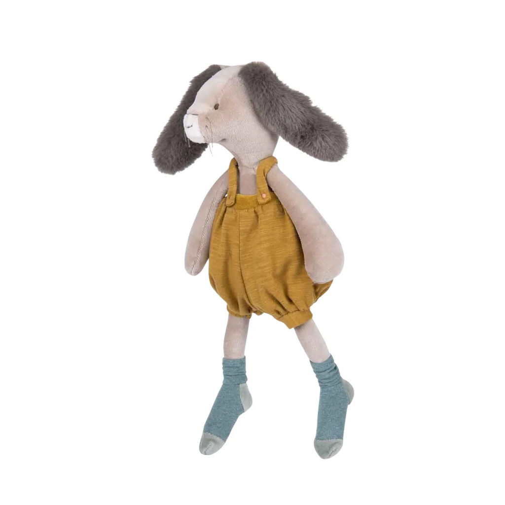 Stuffed animal rabbit wearing mustard yellow overalls on a white background